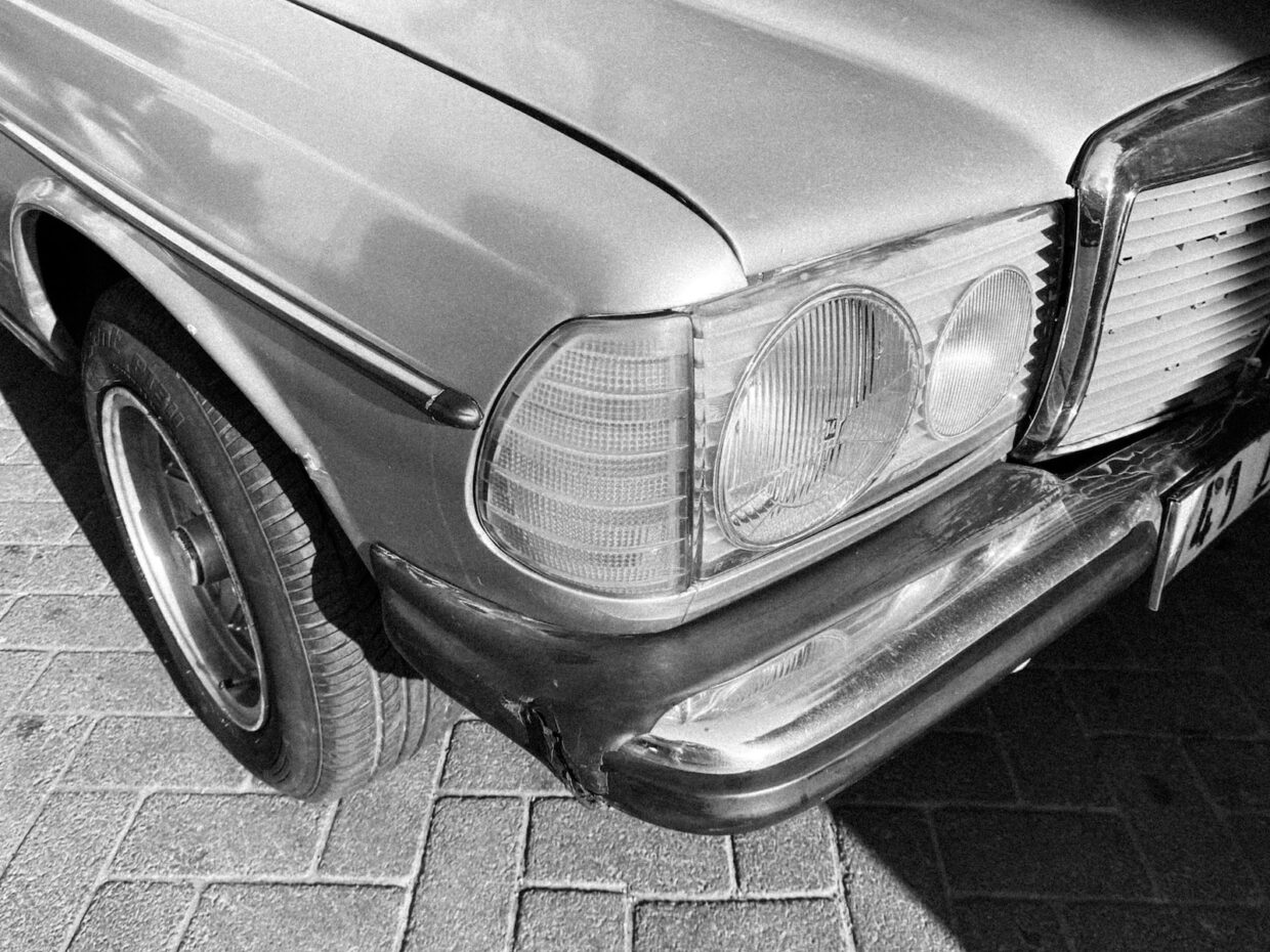 grayscale photo of car on brick floor