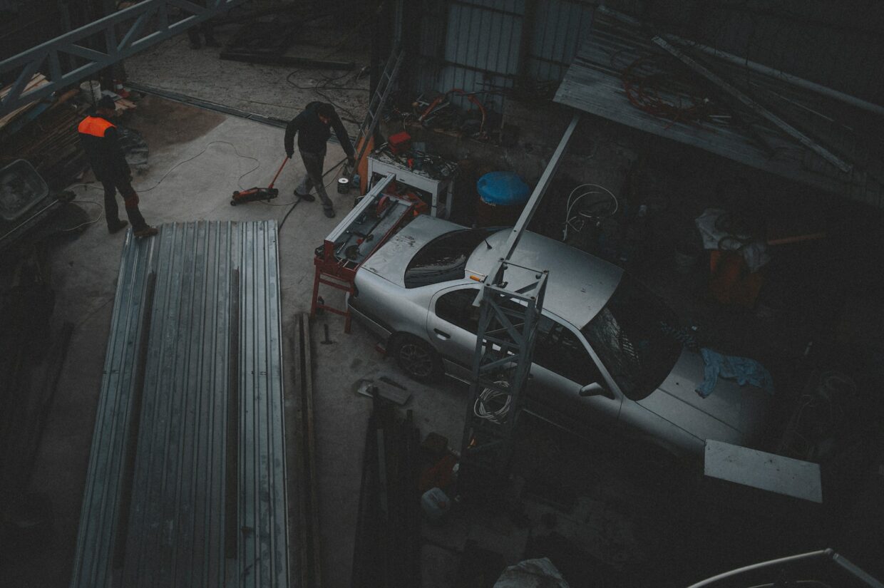 two men working on a car in a garage